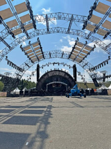 Die im Aufbau befindliche Mainstage der Nature One. Über dem Vorplatz der Bühne wölben sich halbrunde Traversen.“